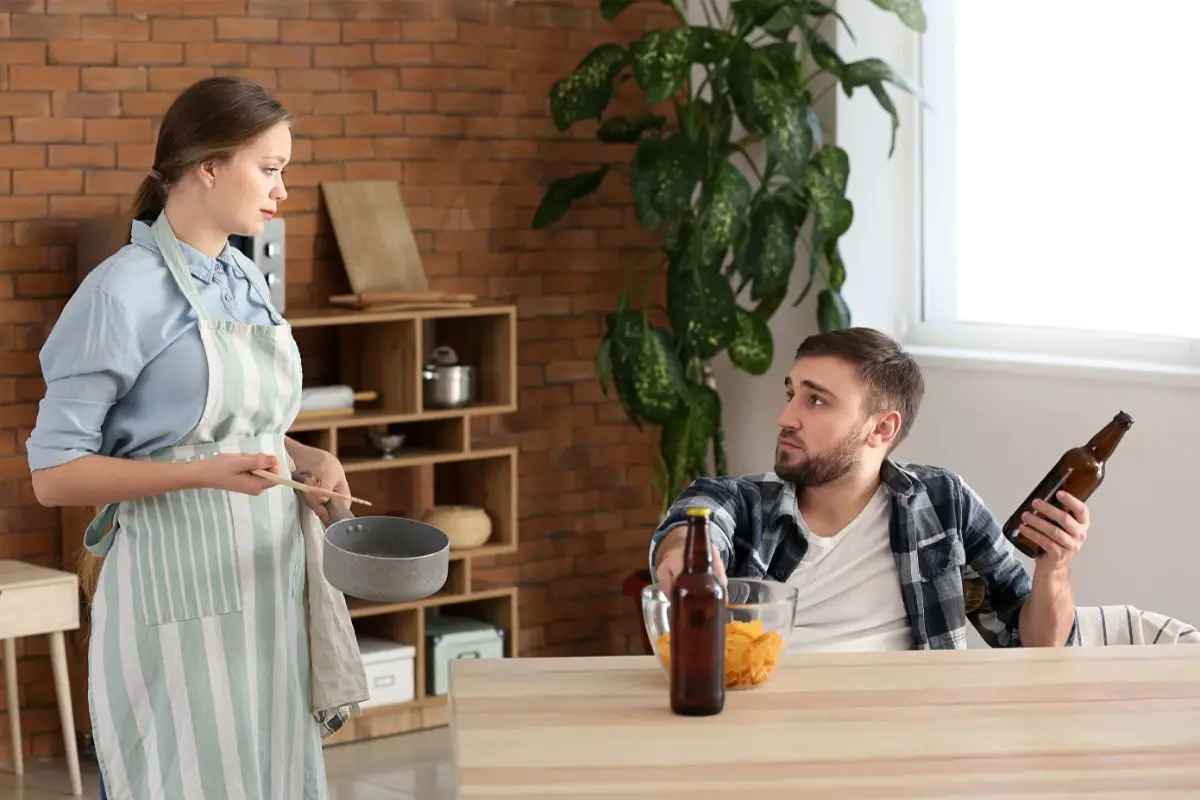 husband-drinking-beer-while-his-wife-cooking-food